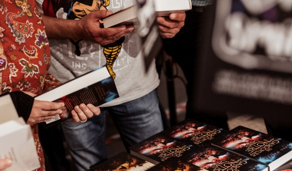 Lecteurs* devant une table de livres BoD