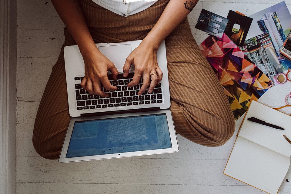 Foto einer Frau, die am Notebook schreibt